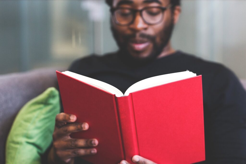 man reading a red book