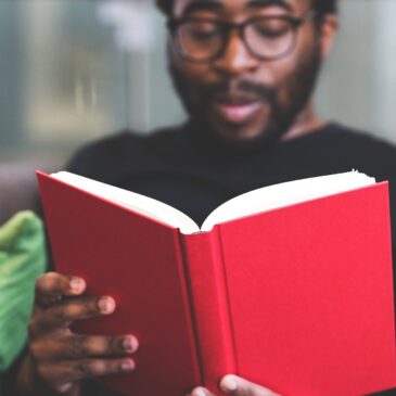 man reading a red book